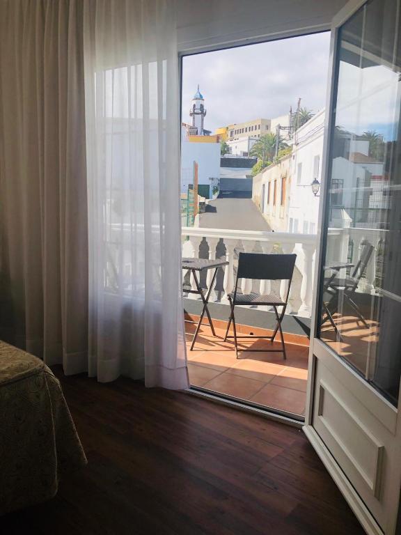 a room with a window and a chair on a balcony at Hotel Boomerang in Valverde