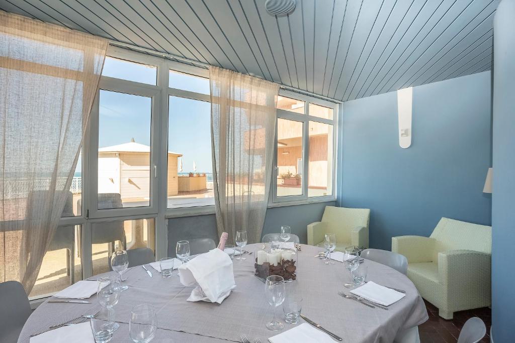 a dining room with a table and a large window at Hotel Rex in Livorno