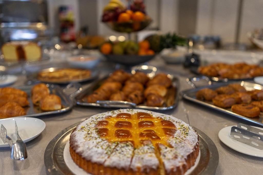 a table topped with a cake and other foods at Hotel Rex in Livorno