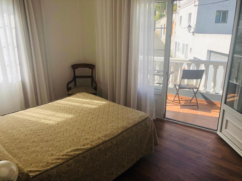 a bedroom with a bed and a view of a balcony at Hotel Boomerang in Valverde