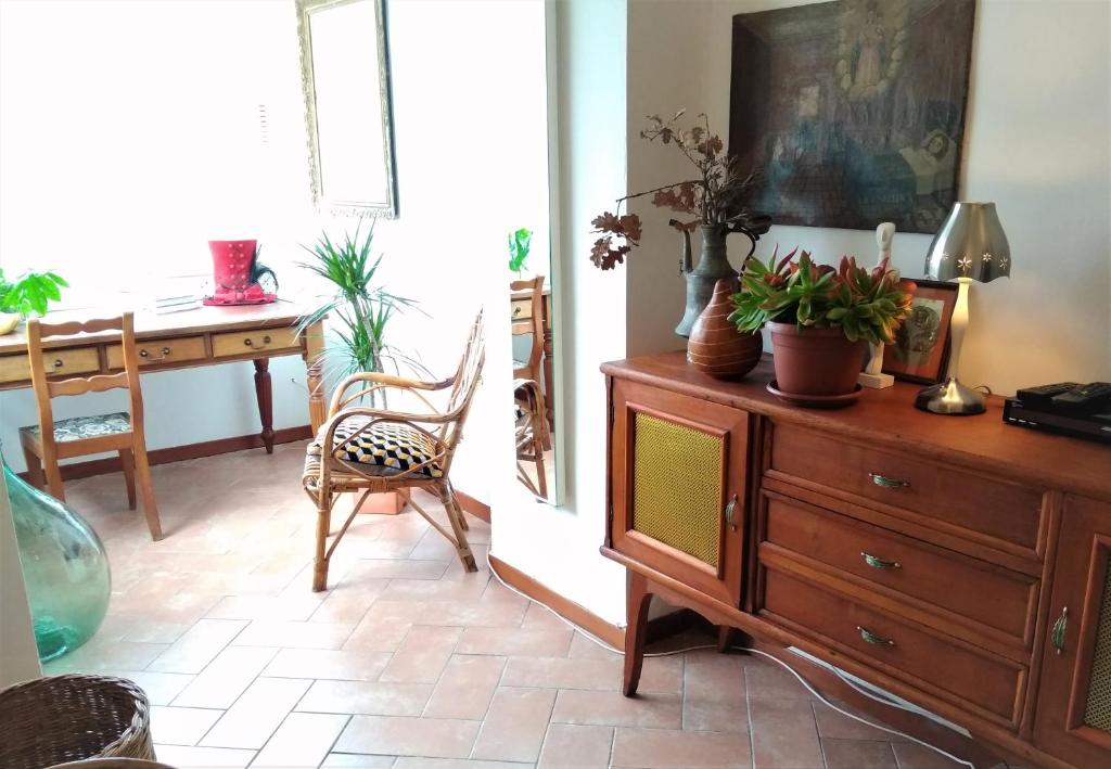 uma sala de estar com uma cómoda de madeira com plantas em La Casetta di Perugia em Perugia