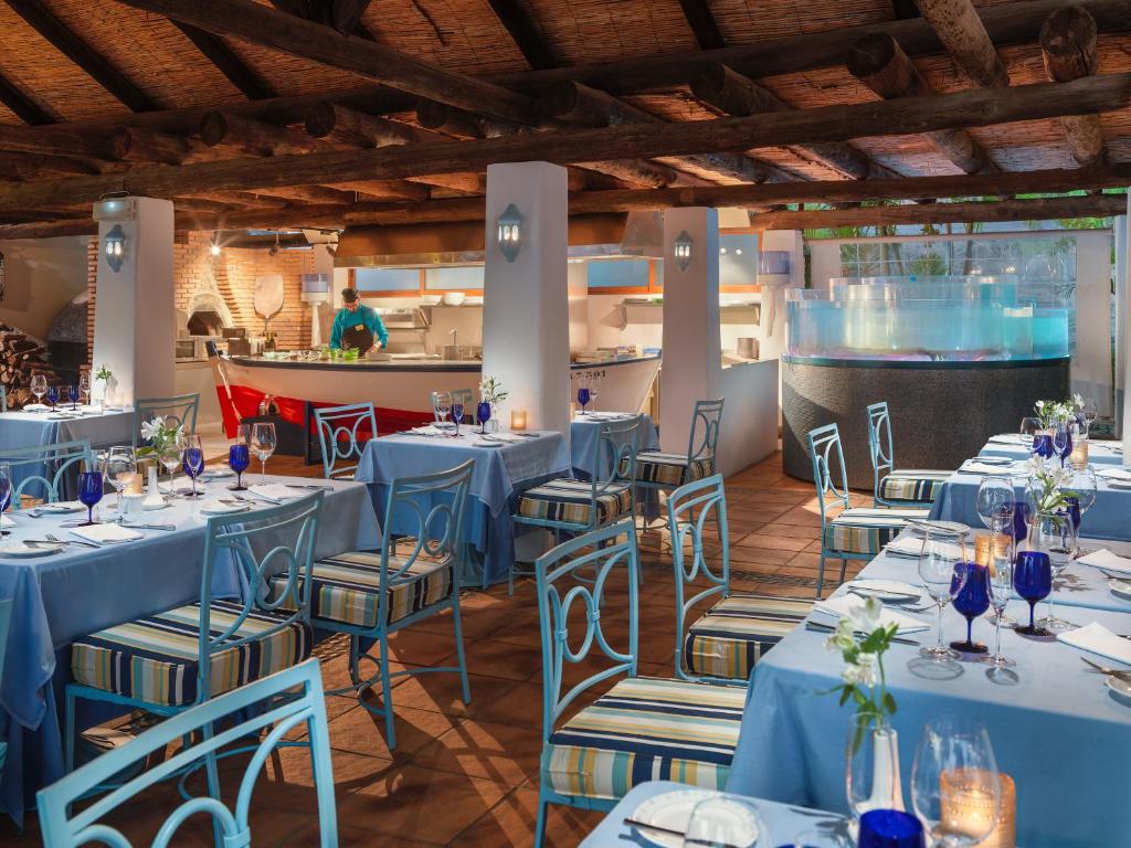 a dining room with blue tables and chairs at Hotel Jardín Tecina in Playa de Santiago