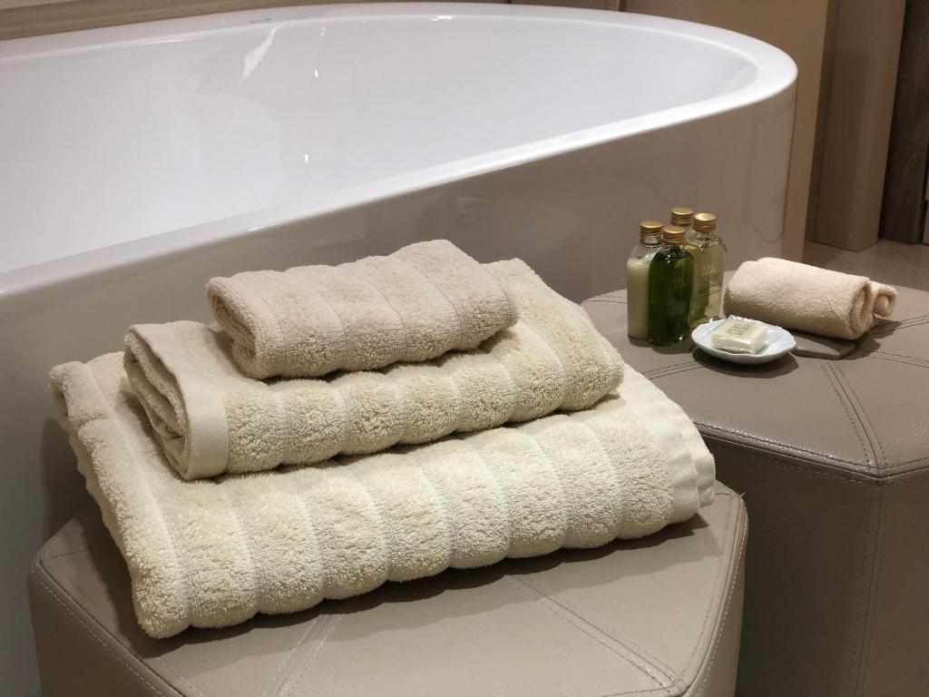 two towels sitting on a table next to a bath tub at Kemer Country Hotel İstanbul in Istanbul