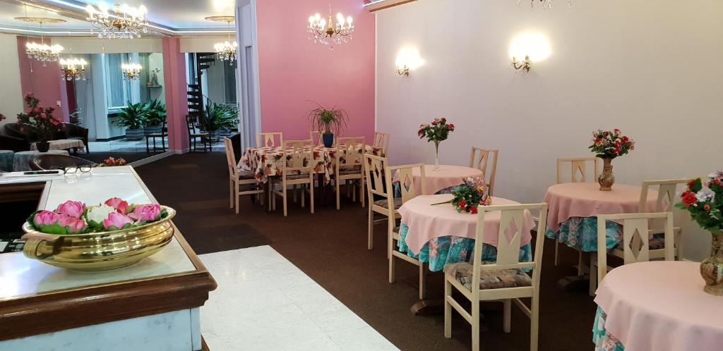a dining room with tables and chairs and pink walls at Saint Francois Xavier in Lourdes