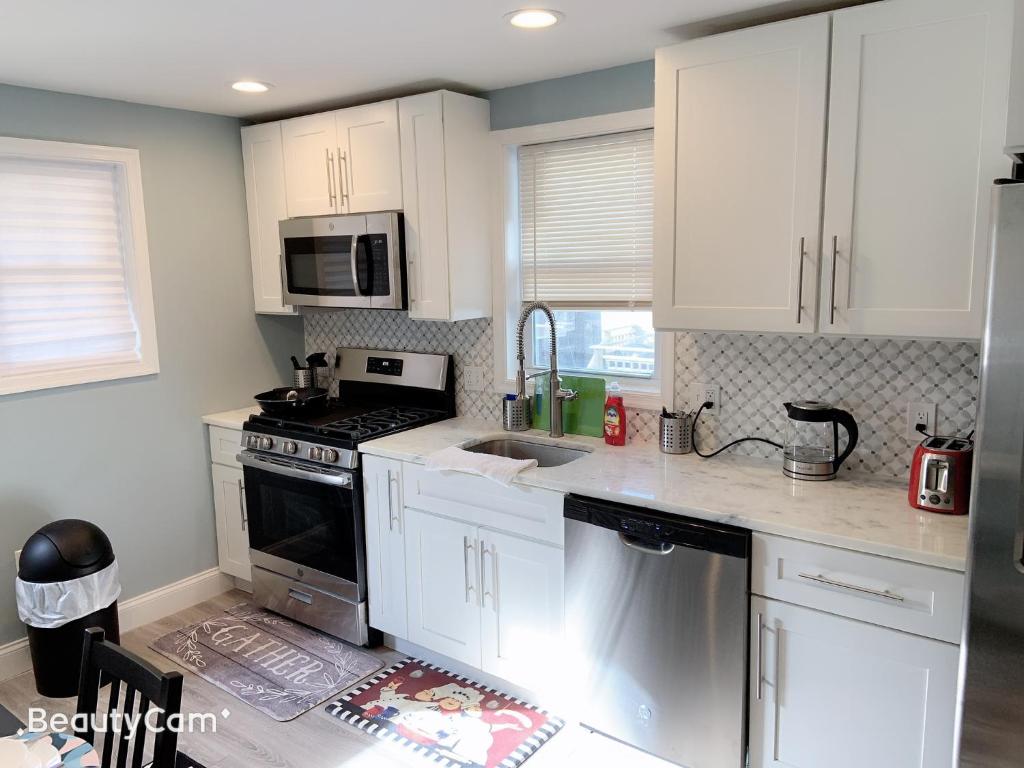 a kitchen with white cabinets and a stove top oven at Nice bedroom next fells point in Baltimore