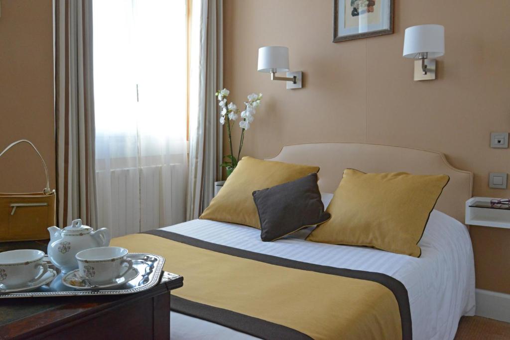 a bedroom with a bed with a tray of tea cups on it at Hotel Splendid in Cannes