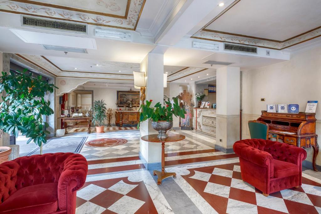 a lobby with two red chairs and a piano at Hotel Villa San Pio in Rome