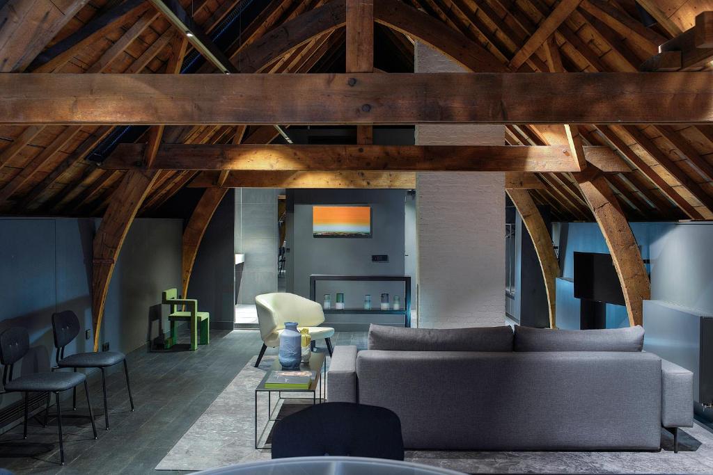 a living room with a couch and chairs at Kazerne - Member of Design Hotels in Eindhoven