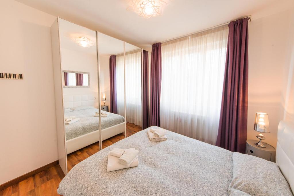 a bedroom with two beds and a large mirror at Zenzero & Cannella Boutique Rooms in Trieste