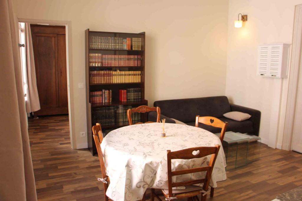 a living room with a table and a couch at Superbe T2 3 étoiles à proximité des thermes et des pistes cyclables in Lamalou-les-Bains
