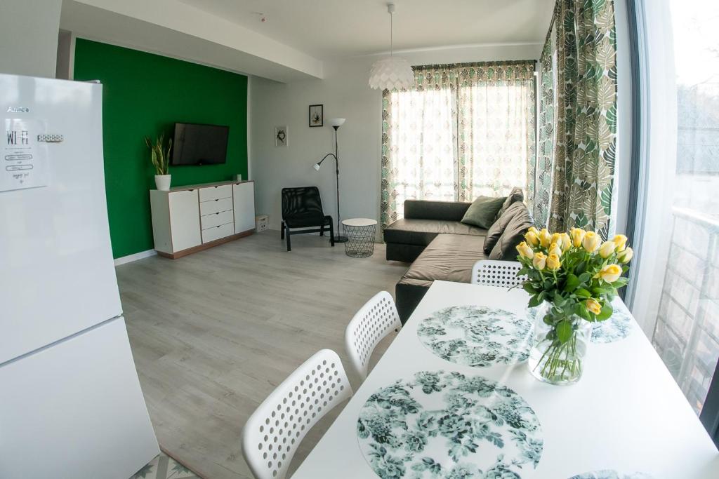 a kitchen and living room with a table and chairs at Zielone Apartamenty in Świeradów-Zdrój