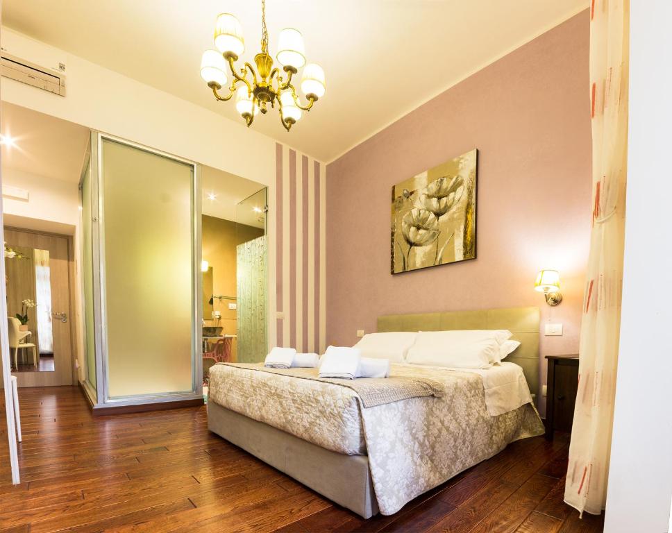 una camera con letto e lampadario a braccio di La Muraglia Di San Pietro a Roma