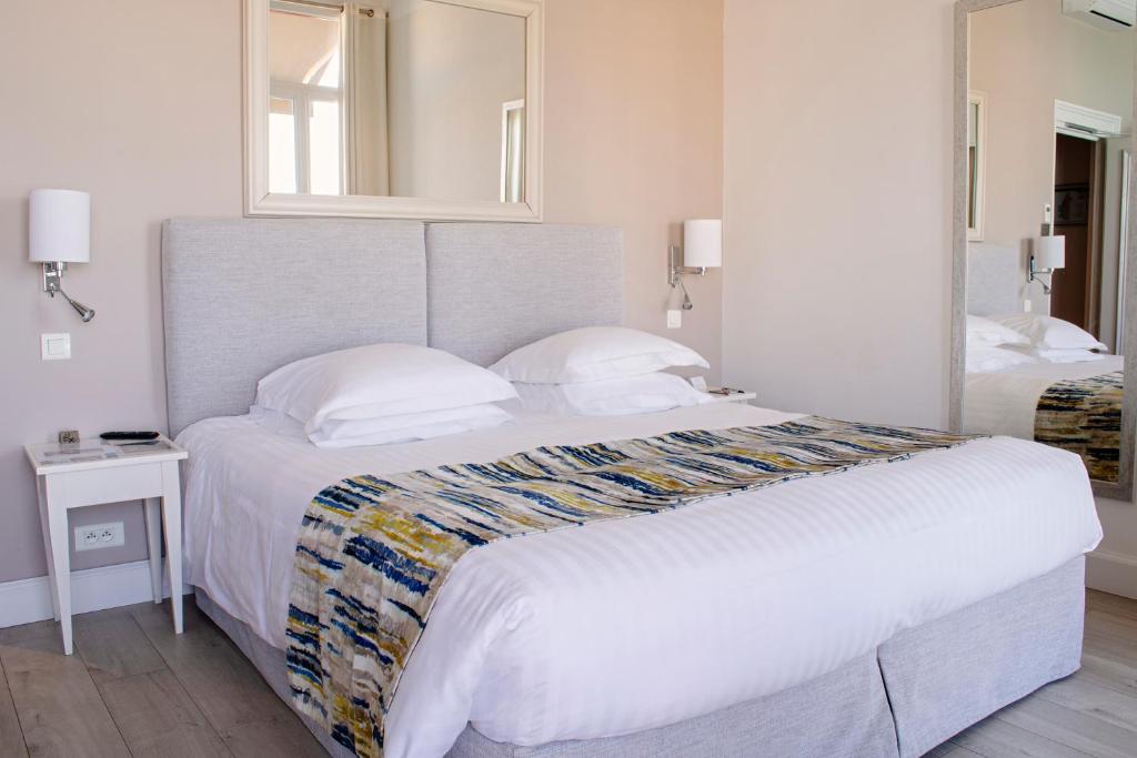 a bedroom with a large bed and a mirror at Hotel Suisse in Nice