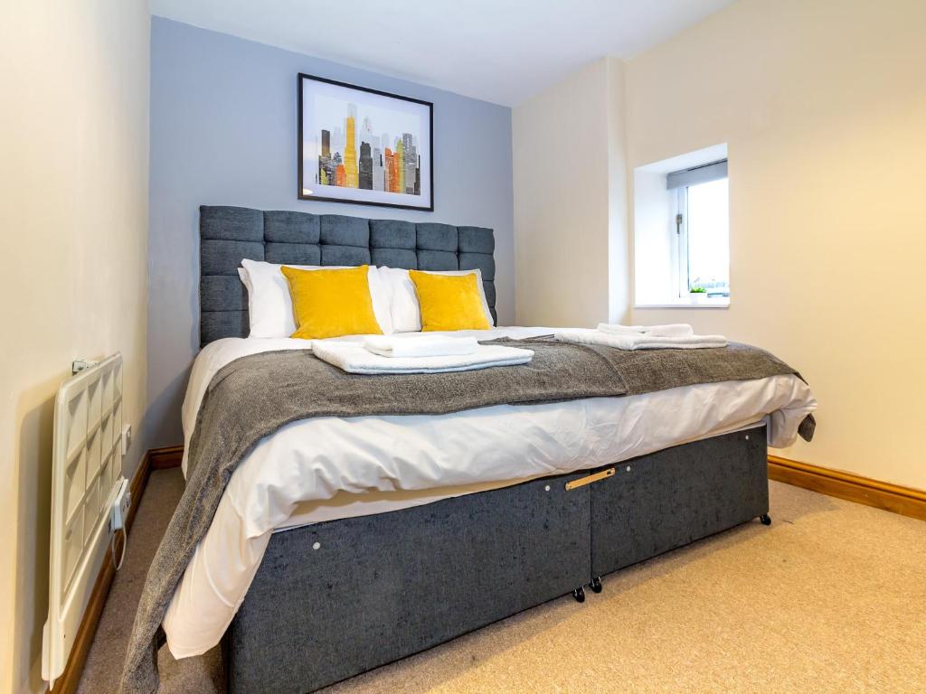 a bedroom with a large bed with yellow pillows at Guest Homes - New Street in Worcester