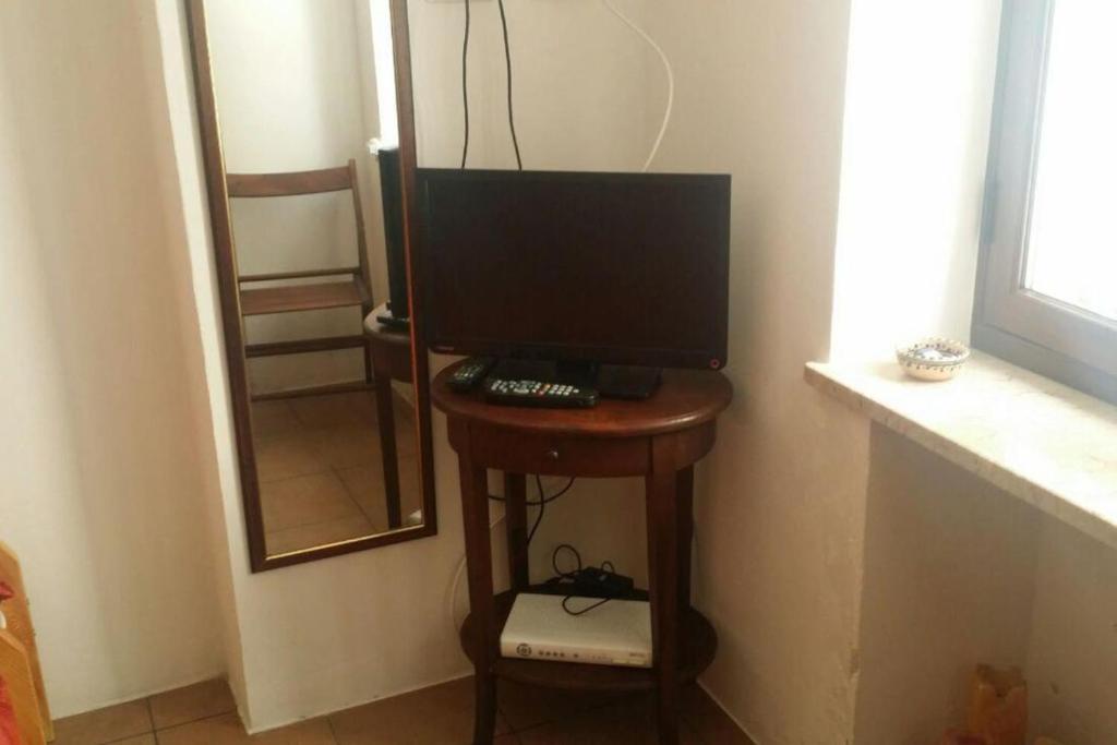 un monitor per computer su un tavolo di legno in una stanza di A Kasuzza a Pantelleria