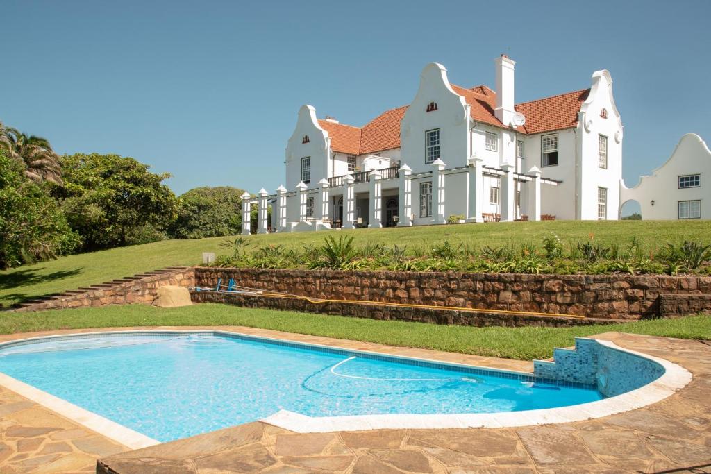uma casa grande com uma piscina em frente em Botha House em Pennington