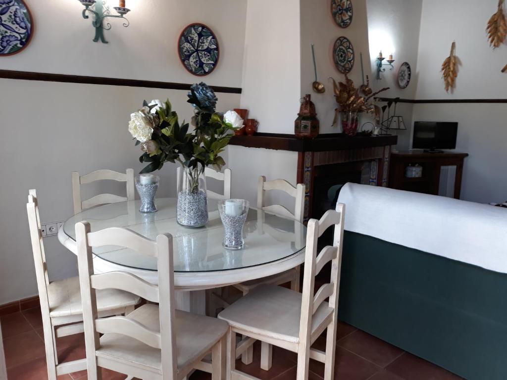 stół z krzesłami i wazon kwiatów na nim w obiekcie Chalet la Huerta 2 amplios jardines barbacoa y WiFi w mieście Conil de la Frontera