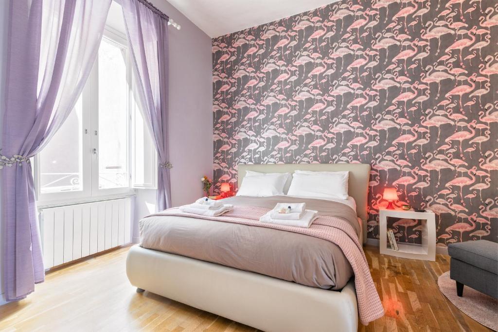 una camera da letto con un letto e carta da parati floreale di Rome As You Feel - Vittorio Colorful Design Apartment a Roma