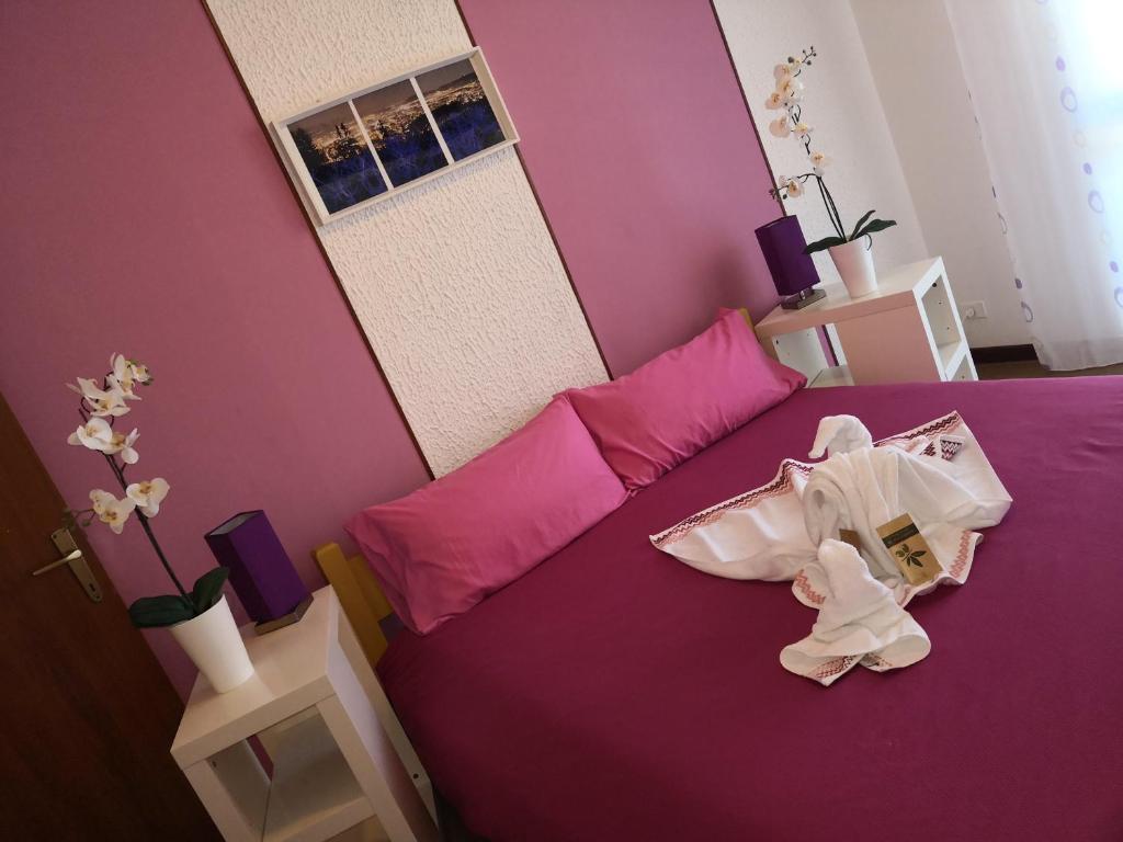 een slaapkamer met een paars bed met schoenen erop bij B&B MANITO in Lavena Ponte Tresa