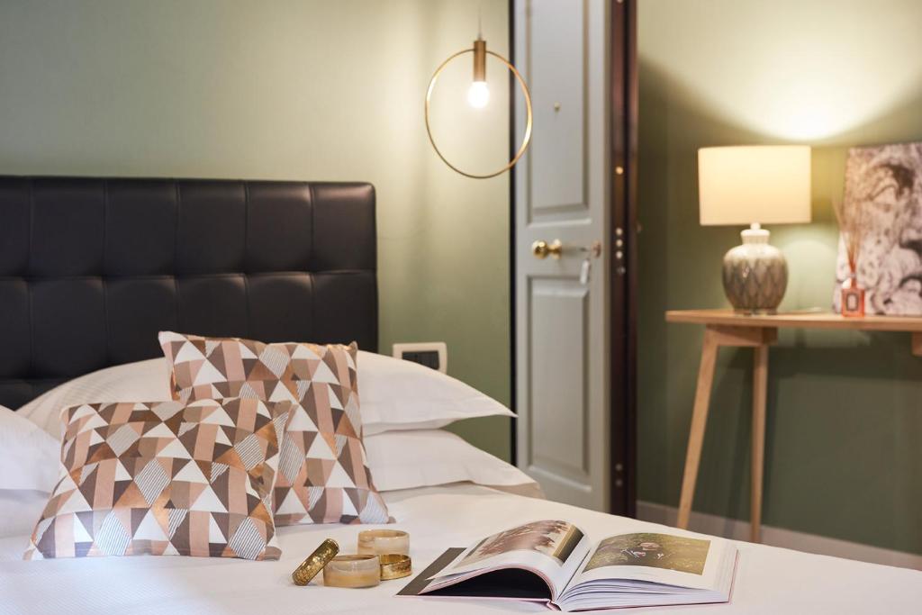 um quarto com uma cama com um livro e um candeeiro em Residence Leopoldo em Florença