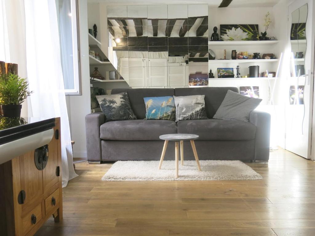 a living room with a couch and a table at Studio Marais Charlot CityCosy in Paris