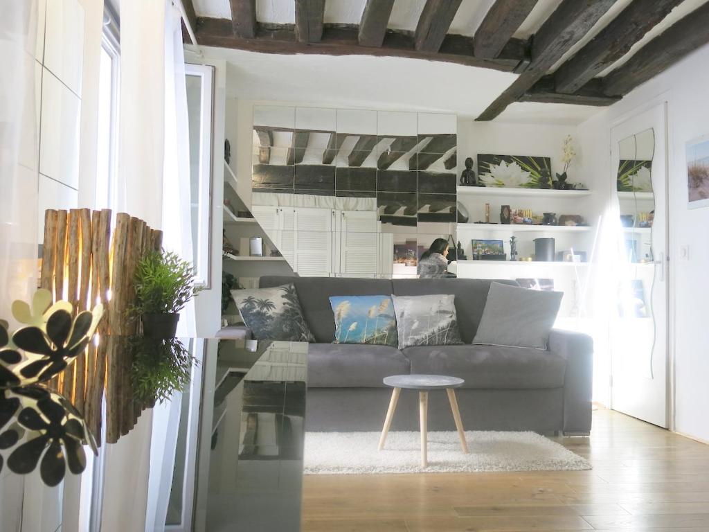 a living room with a couch and a table at Studio Marais Charlot CityCosy in Paris