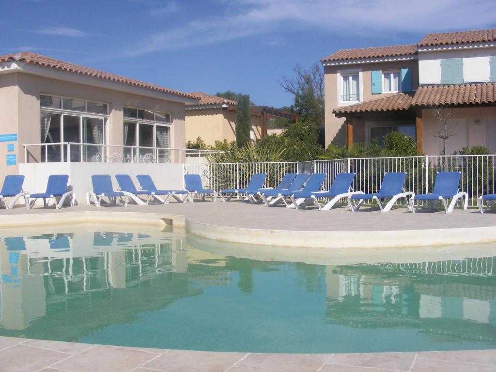 - un groupe de chaises longues bleues à côté de la piscine dans l'établissement Lagrange Vacances Les Bastides des Chaumettes, à Montauroux