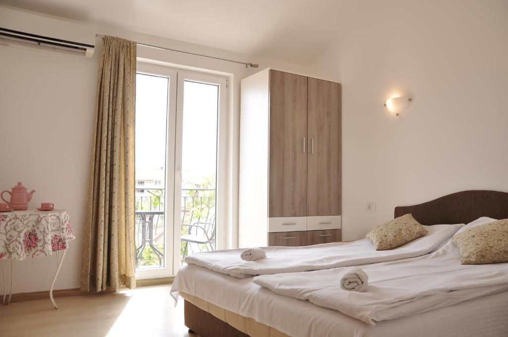 a bedroom with two beds and a large window at Guest House Damjana in Budva