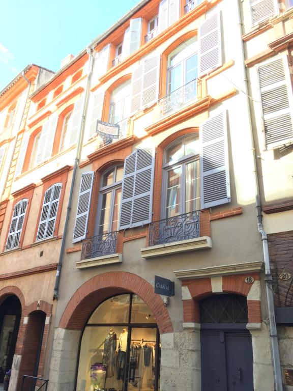 トゥールーズにあるAppartement de charme, Croix Baragnon, Toulouseの窓に白いシャッターが付いている建物