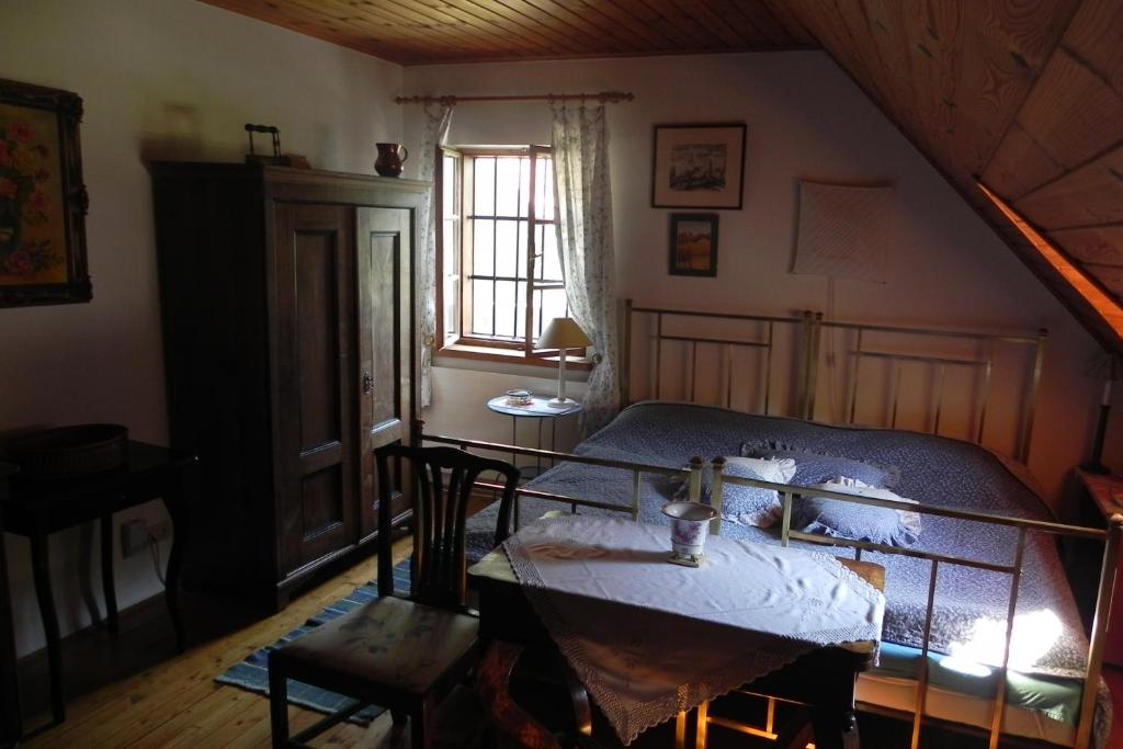 a bedroom with a bed and a table and a window at Ferienhaus Himmelreichmühle in Rettenberg