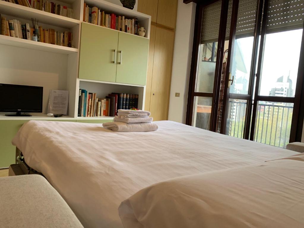 a bedroom with a large white bed with a tv at Kibilù - Via Cimabue in Milan