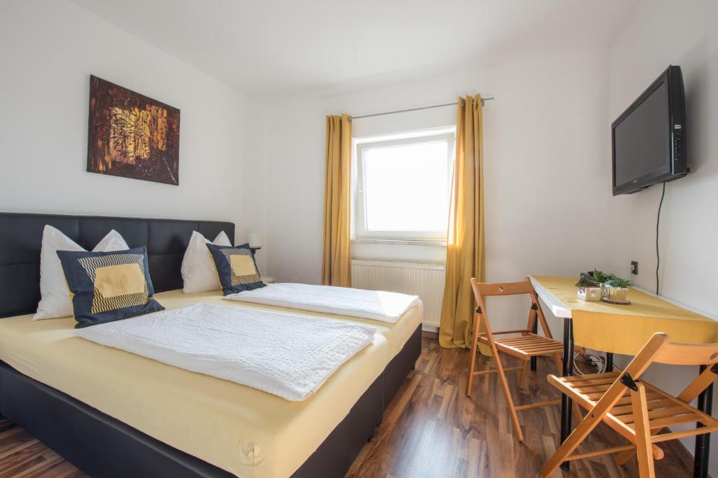 um quarto com uma cama, uma mesa e uma secretária em Pension Rosenhof em Linz