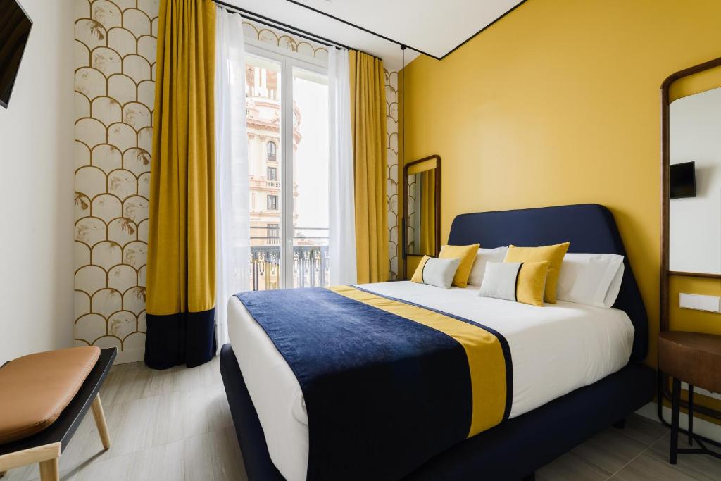 ein Hotelzimmer mit einem Bett und einem Fenster in der Unterkunft Smartrental Collection Gran Vía Centric in Madrid