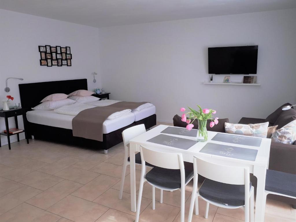 een slaapkamer met een bed en een tafel en stoelen bij Aurora Apartments in Bad Homburg vor der Höhe