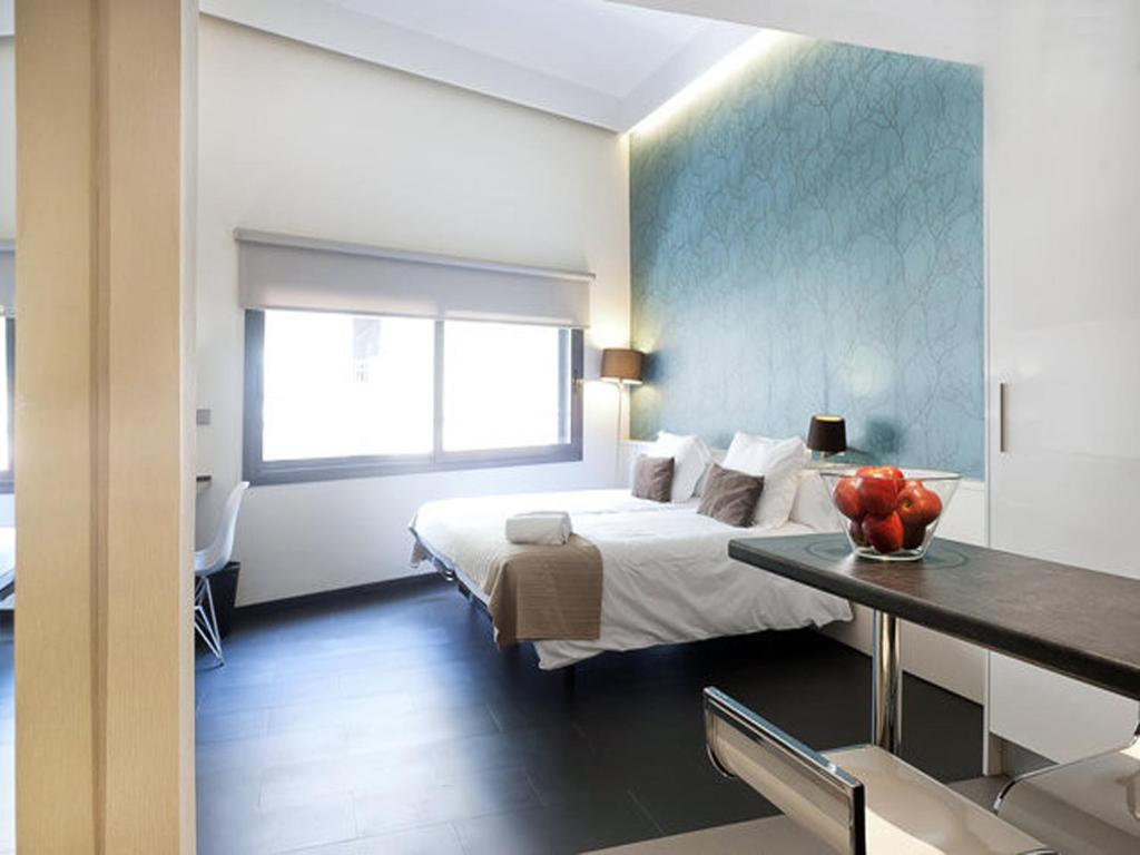 バルセロナにあるBarcelona Fifteen central Aparthotelのベッドルーム1室(ベッド1台、フルーツ付きのテーブル付)