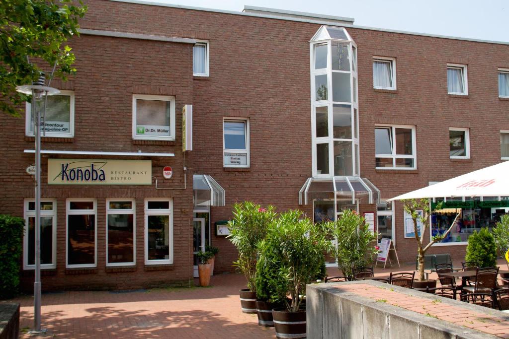 a brick building with tables and chairs in front of it at Konoba in Meckenheim