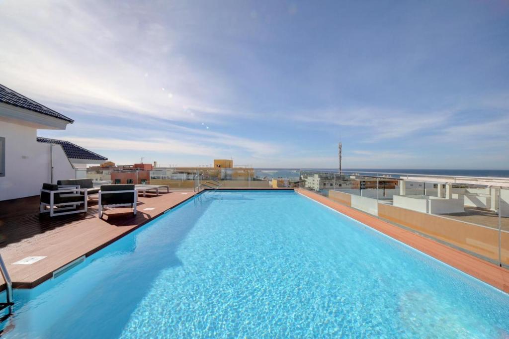 a large swimming pool on the roof of a building at Ventum Suite in Tarifa