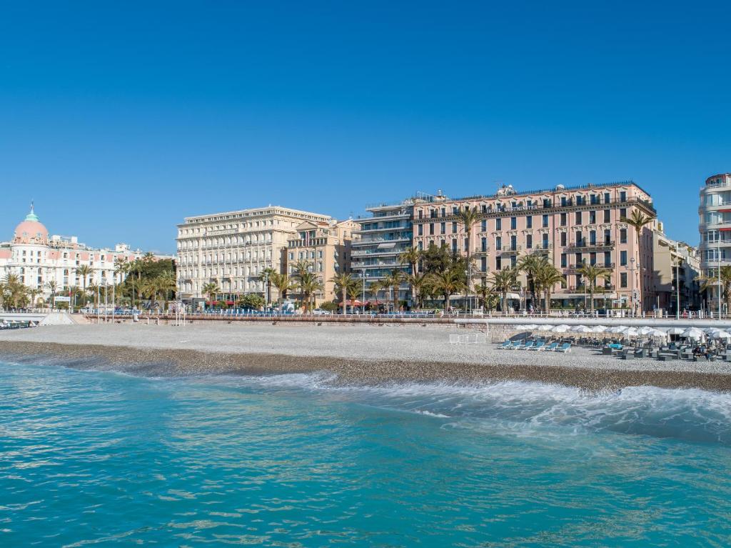a view of a beach with buildings in the background at Westminster Hotel & Spa Nice in Nice