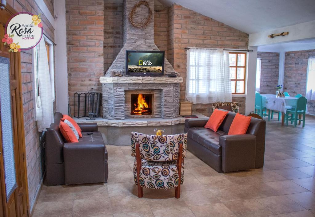 a living room with two couches and a fireplace at Santa Rosa de Lima Hostal Zuleta in Zuleta