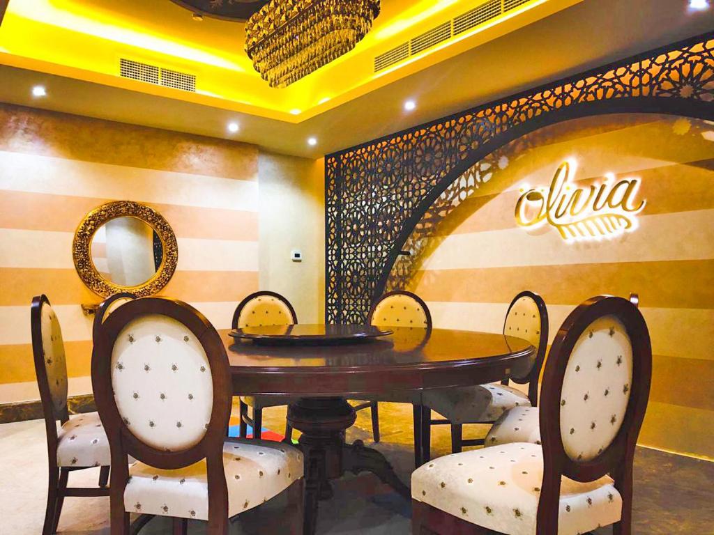 a dining room with a wooden table and chairs at Mangrove Hotel in Ras al Khaimah