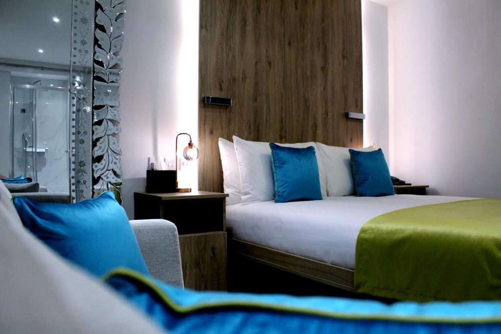 une chambre d'hôtel avec un lit et une chaise dans l'établissement 1 Craven Hill Gardens, à Londres