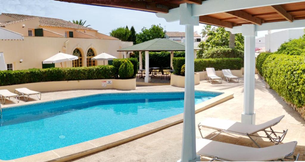 einen Pool mit Stühlen und ein Haus in der Unterkunft Hotel Rural Son Tretze - Adults Only in Sant Lluís