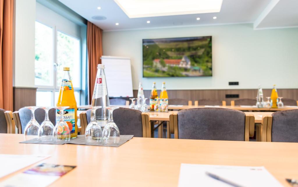 una sala conferenze con tavoli e sedie con bottiglie sopra di Hotel Waldmühle a Zella-Mehlis