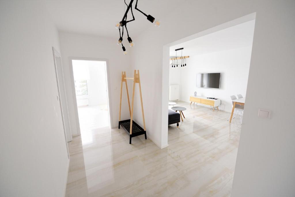 a living room with white walls and a wooden floor at Center Aupark Apartment in Piešťany