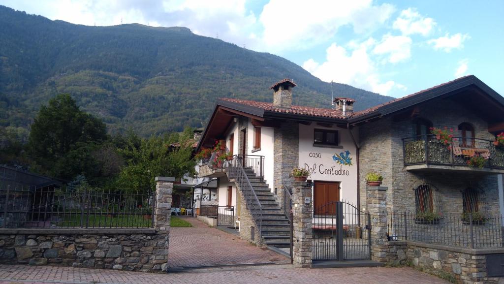 a building with a staircase in front of a mountain at Casa Vacanza Dal Contadino CIR O17063 in Alpe Strencia