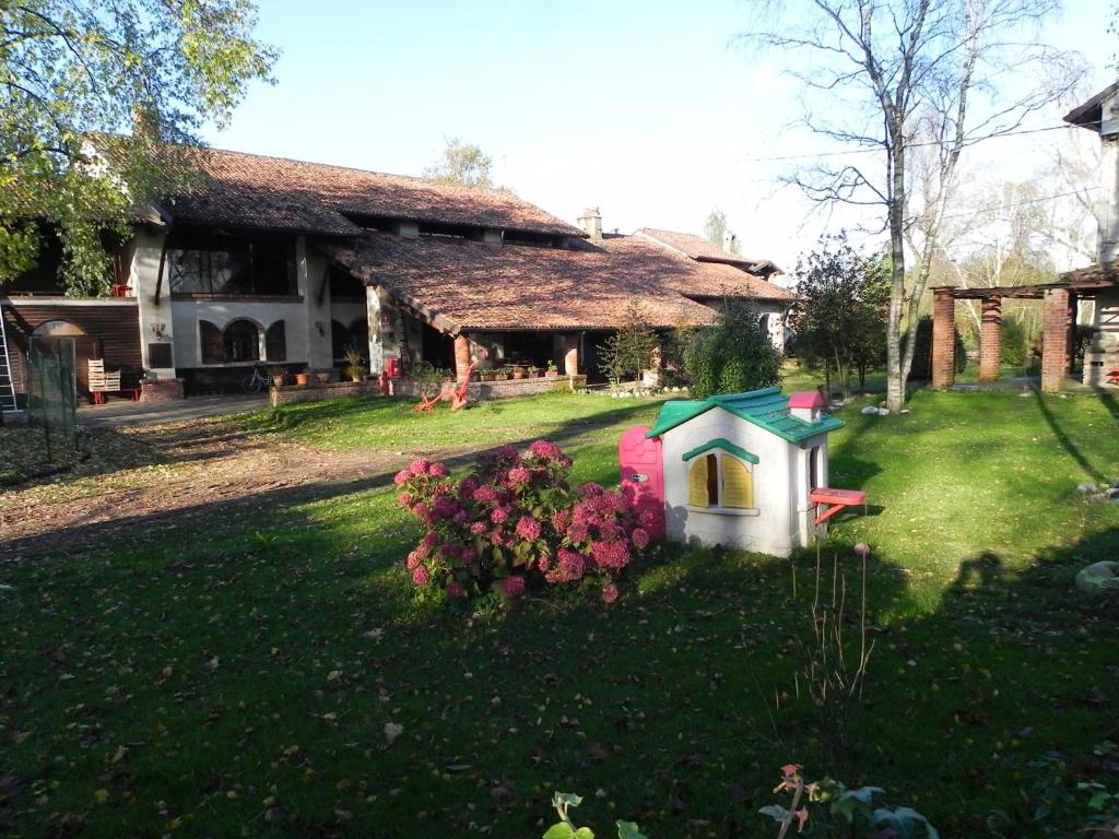 ein Haus mit einem Hundehaus im Hof in der Unterkunft Agriturismo Cascina Poscallone in Abbiategrasso