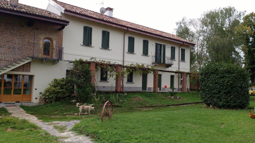 dom z psem stojącym przed nim w obiekcie Agriturismo Cascina Poscallone w mieście Abbiategrasso
