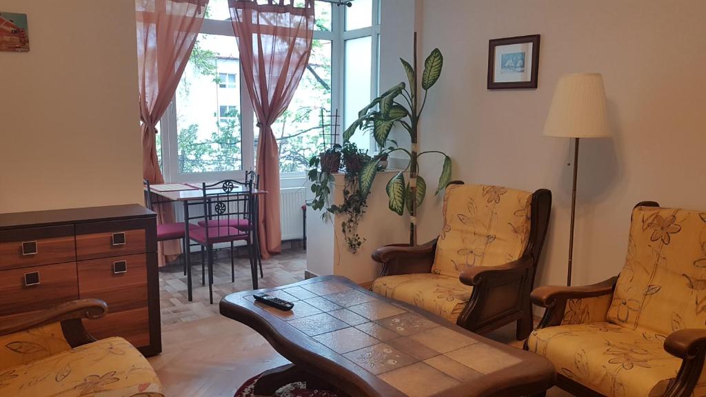sala de estar con 2 sillas y mesa de centro en Eden Apartament, en Bucarest