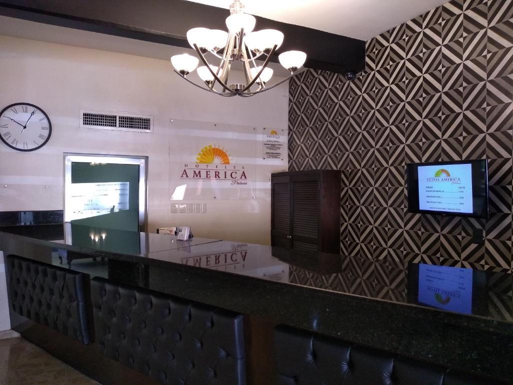 eine Bar in einem Restaurant mit einer Uhr an der Wand in der Unterkunft Hotel America Palacio in Los Mochis