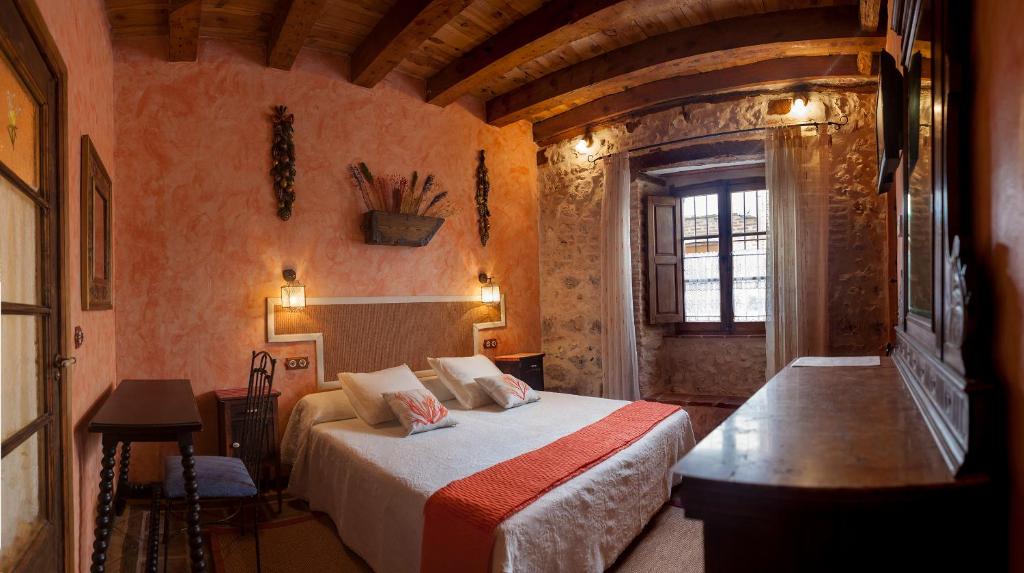 a bedroom with a bed and a window in a room at Hotel Rural La Enhorcadora in Portillo